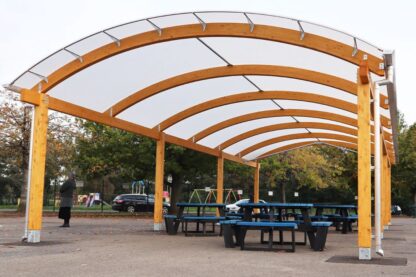 Photo of playground canopy in a school, with dining tables set up undernead the vast canopy.