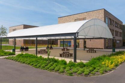 Picture of vast school canopy with school students sitting at tables enjoying the outdoor space
