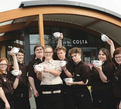 Picture shows COSTA coffee staff holding coffee cups outside their new COSTA coffee pod building in Norwich.