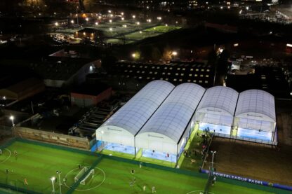 Picture shows new padel court roof cover from the outside at Powerleague Manchester at night