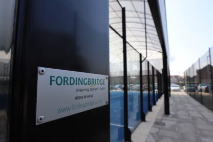 Wrexham Tennis & Padel Centre. It shows the structure from the side with a Fordingbridge sign attached to the outside of the building