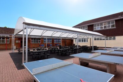 Picture shows new social hub canopy at Five Acres High School with table tennis tables in the foreground