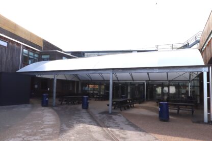 All-weather outdoor dining canopy with a barrel-vaulted Opal 60 roof at Melksham Oak Community School, providing covered seating in the courtyard.