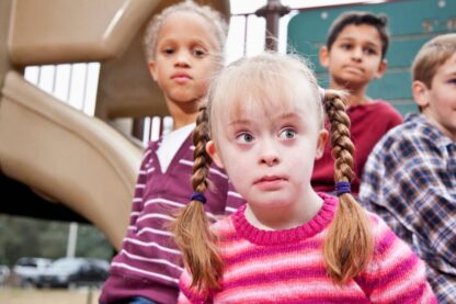 Children sitting together on outdoor playground equipment during school playtime
