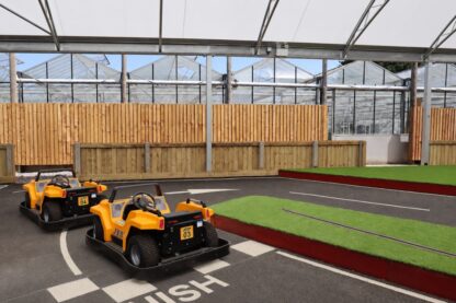 All-weather canopy covering a children's mini racetrack with ride-on cars at Craft Nurseries garden centre in Essex
